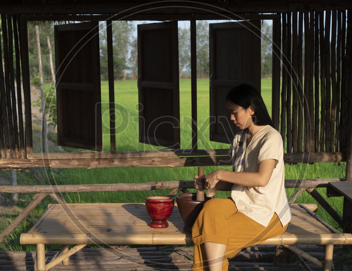 Thai Woman  Using Traditional Thai Wooden Attrition grinder At Country Side
