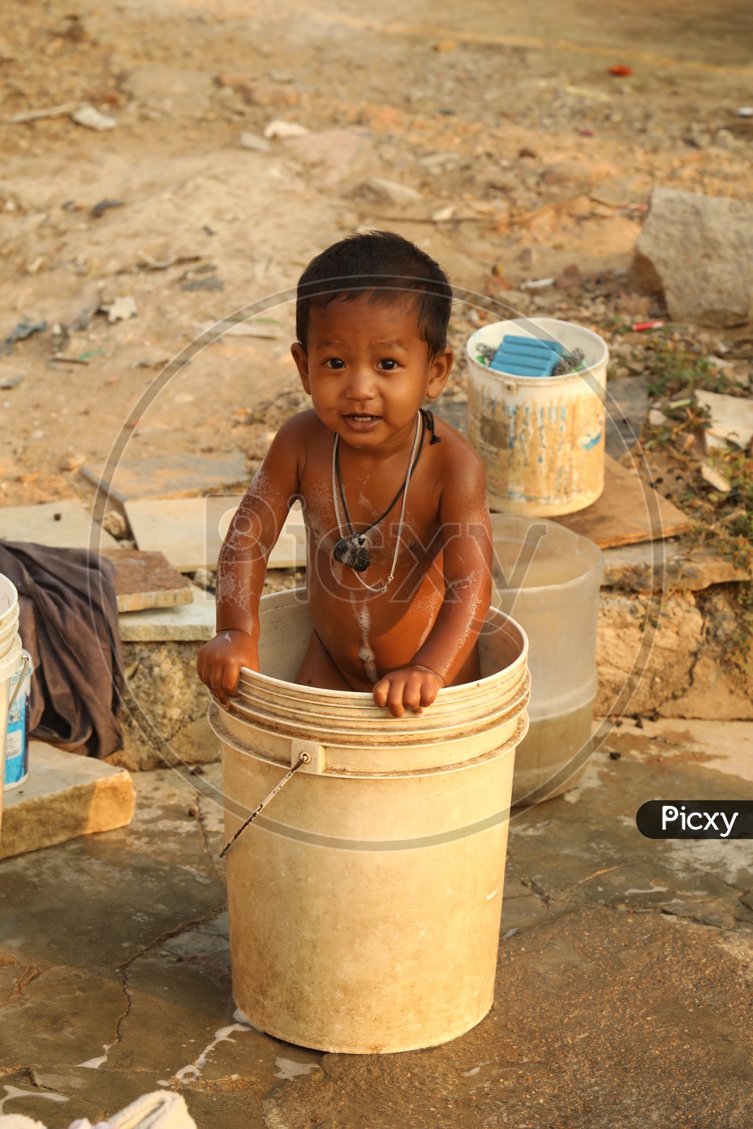 A Child playing with water in a bucket