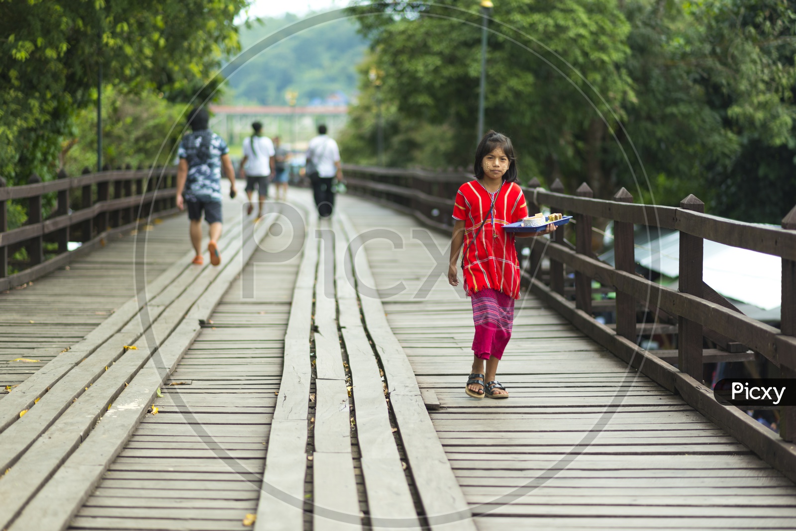 Cute Mon girls walking on wooden  bridge, longest wooden bridge in Mon village, Sangklaburi, Kanchanaburi, Thailand