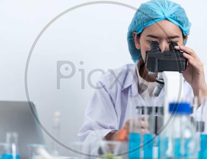 Researcher or scientist Using Microscope In a Laboratory for experiments
