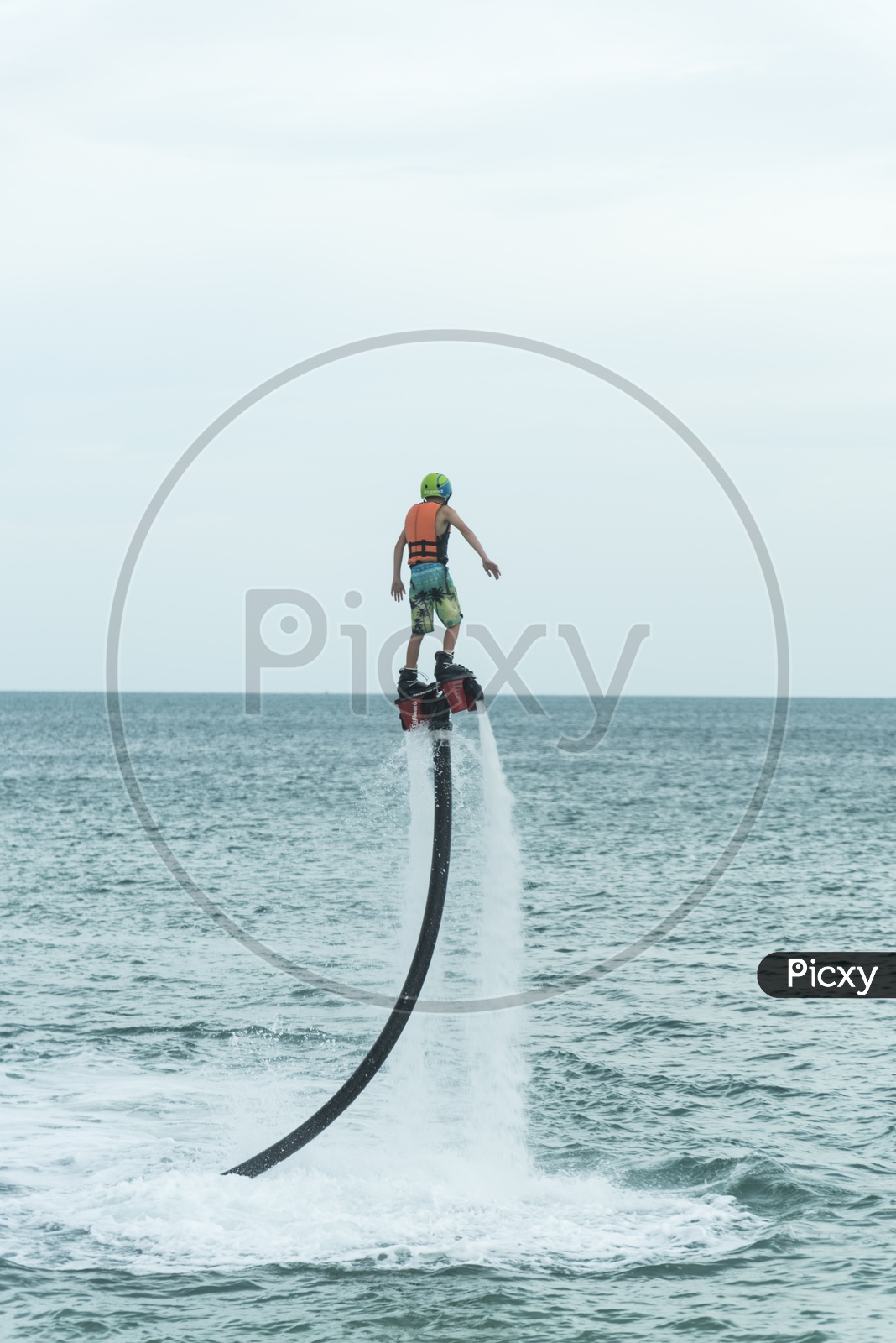 An unidentified guy is playing with a new water sport called fly board at bay in Phuket, Thailand