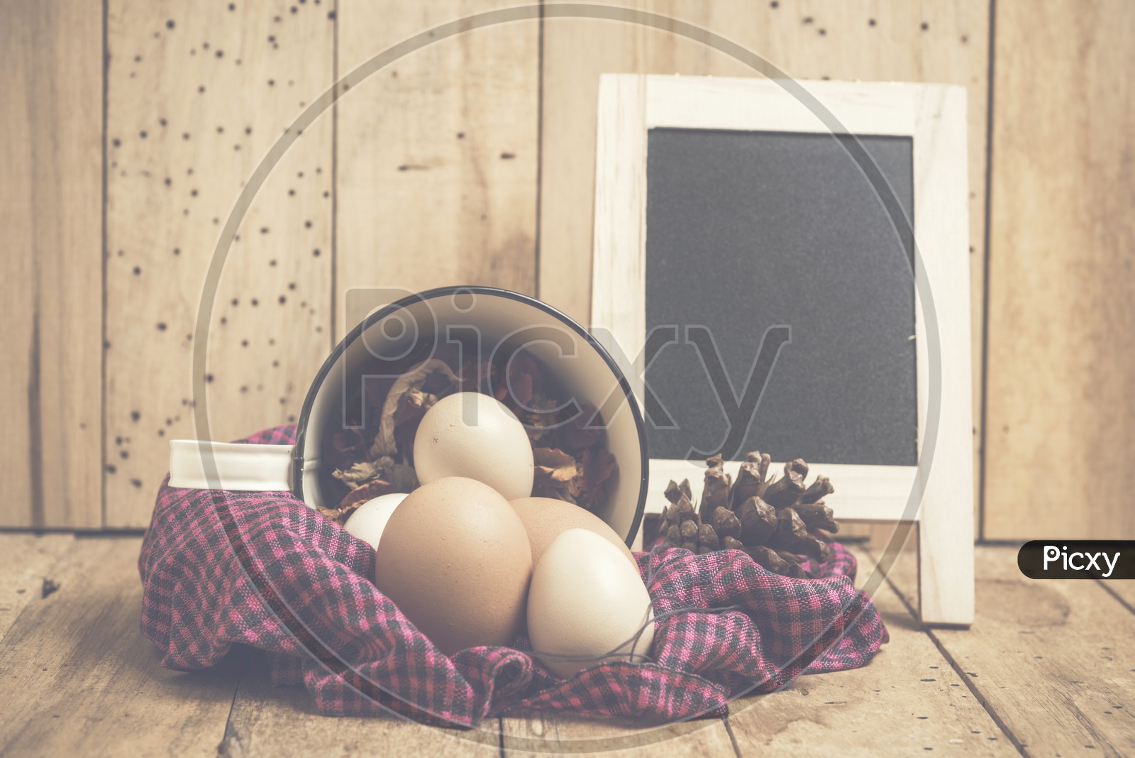 Easter Eggs In a Basket With Vintage Filter Over Wooden Backdrop