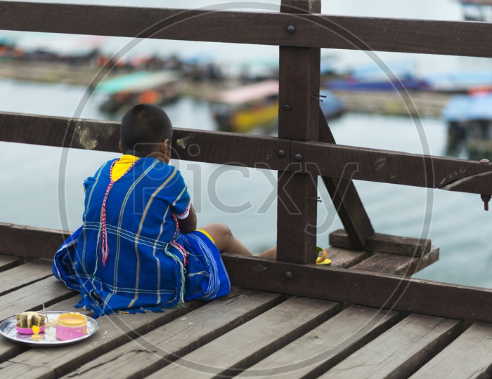 Mon Boy Sitting At Wooden Bridge in Sangkhla Buri