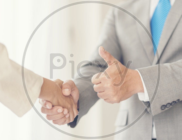 Business Success Greetings Concept With Business Partners Shaking Hands And Thump up Gesture Closeup