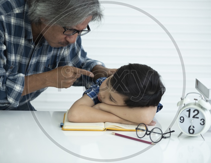 A man is waking up a kid while sleeping at the study table