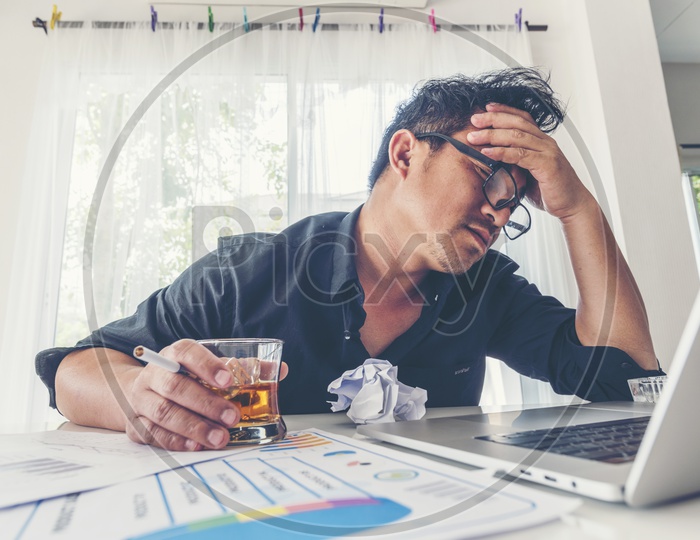 alcohol addicted  drunk businessman holding a glass of whiskey At Office Desk Backdrop