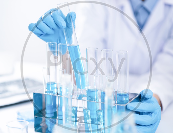 Laboratory Setup With Chemical beakers And researcher Performing Experiments Closeup