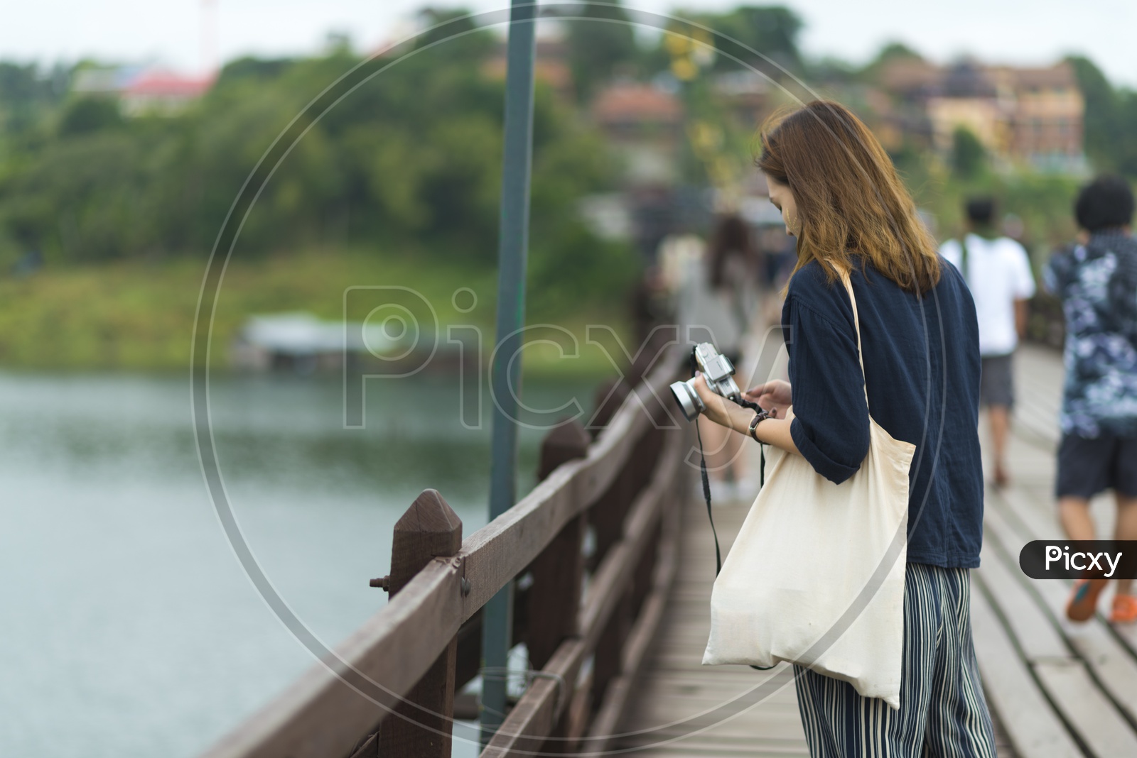 Tourist Woman With Camera In Hand At Wooden bridge