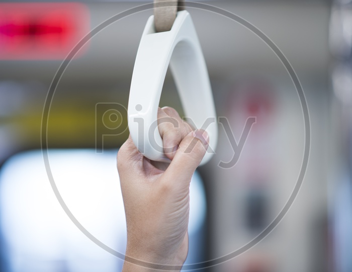 Commuters Hands Holding Support Handle bars in train Closeup