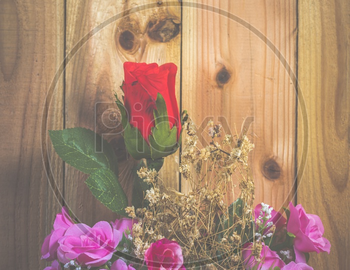 Rose Flowers Set in a Vase Over a Wooden Background