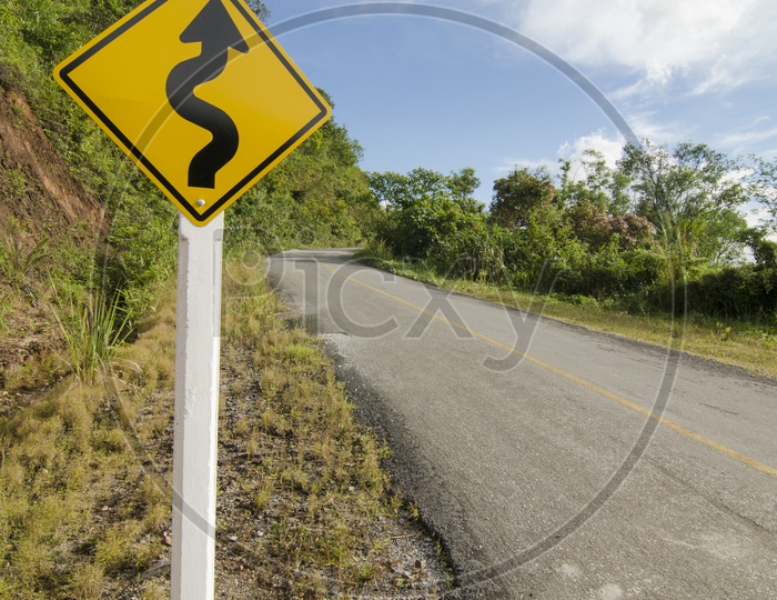 S Curve Sign with Road and Sky in Background