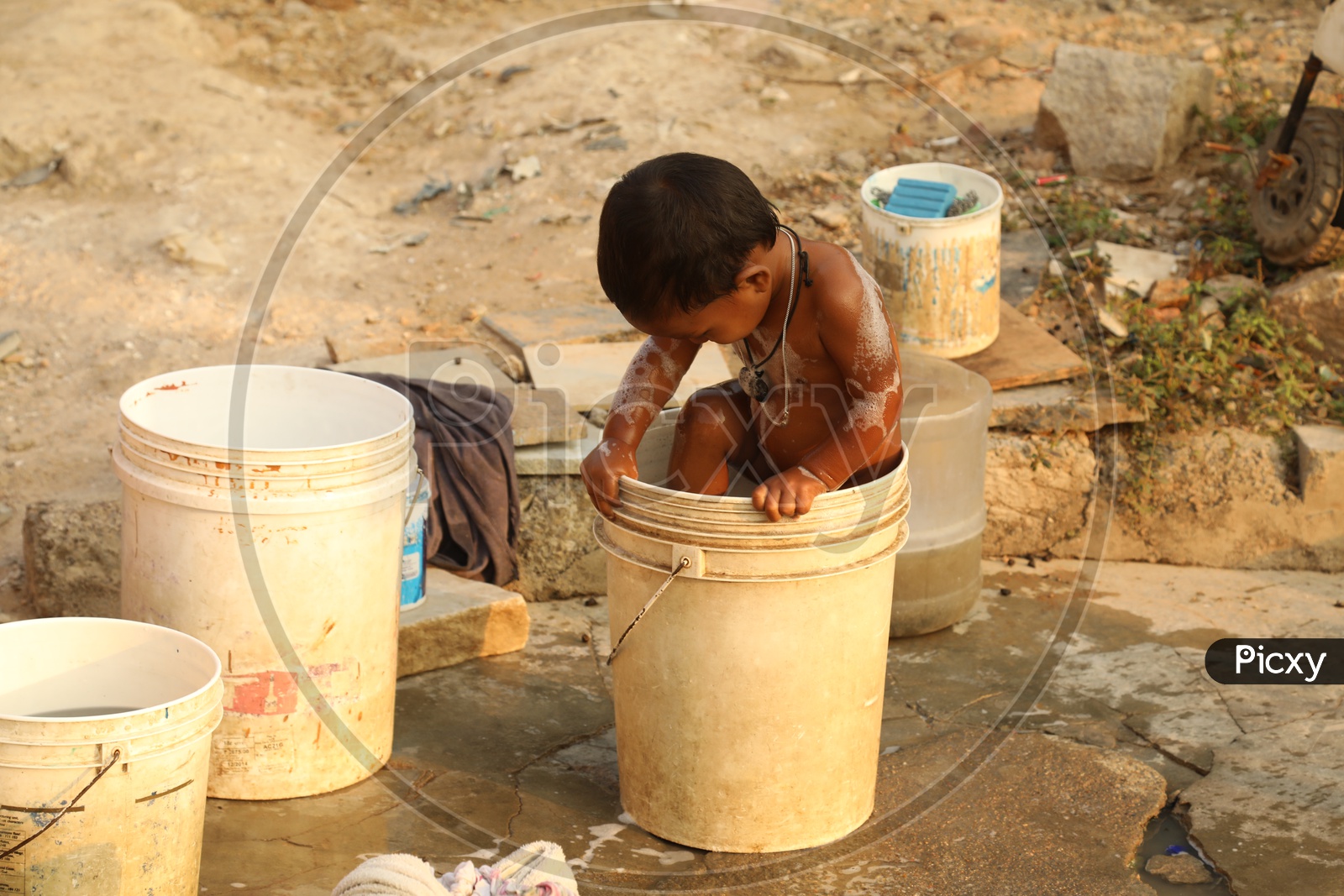 A Child taking bath in a bucket