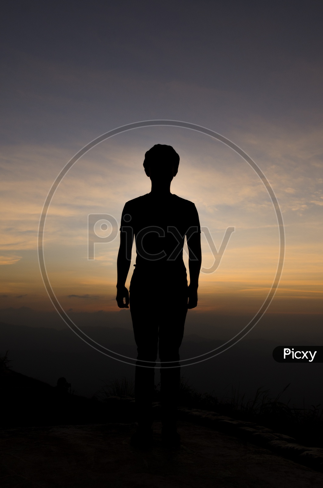 Silhouette of a Young Boy Over Sunset Sky