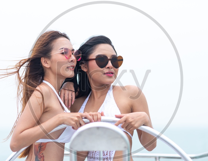 Woman or Asian Girls Posing In Bikinis At A Yacht Party Wearing Bikini