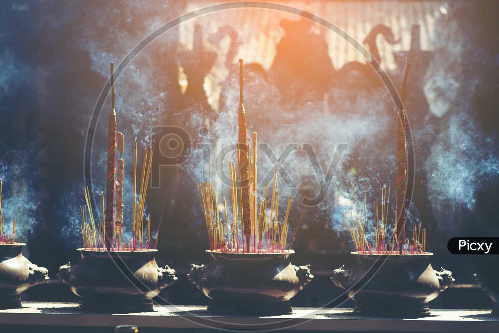 Incense Sticks Burning With Smoke Patterns In Buddhist Temple