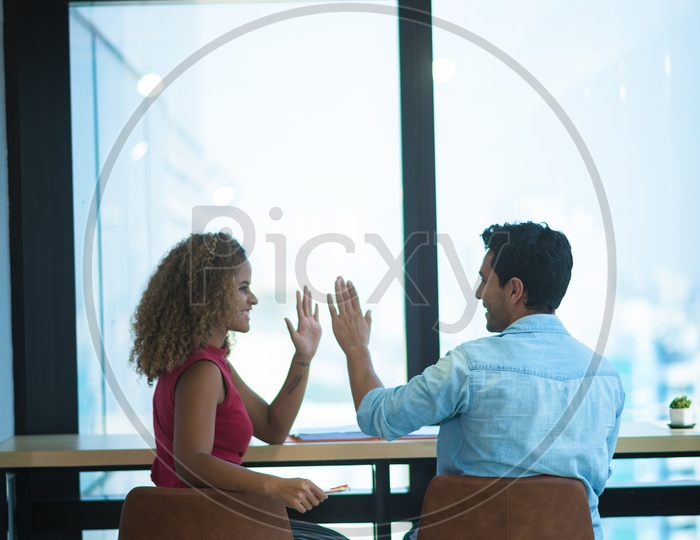 Young Coworkers in Office Discussing Business Strategy and giving High Five