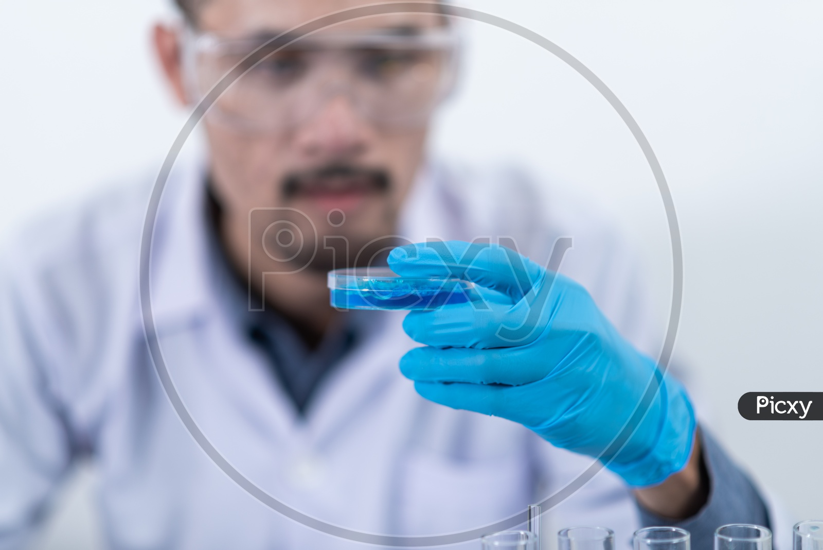 Young Asian Male Scientist Researching Chemical Solutions in Test Tube at Laboratory