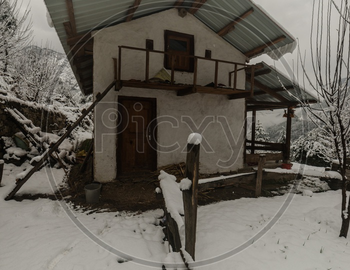 Snow covered wooden house in himalayas in winters - India