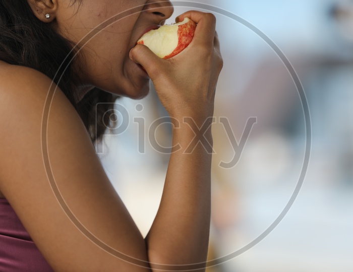 Indian Woman eating an Apple