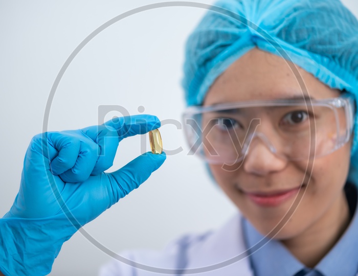 Young Asian Woman Scientist Holding Fish oil Capsule or Pill in Hand, Healthy Nutrition