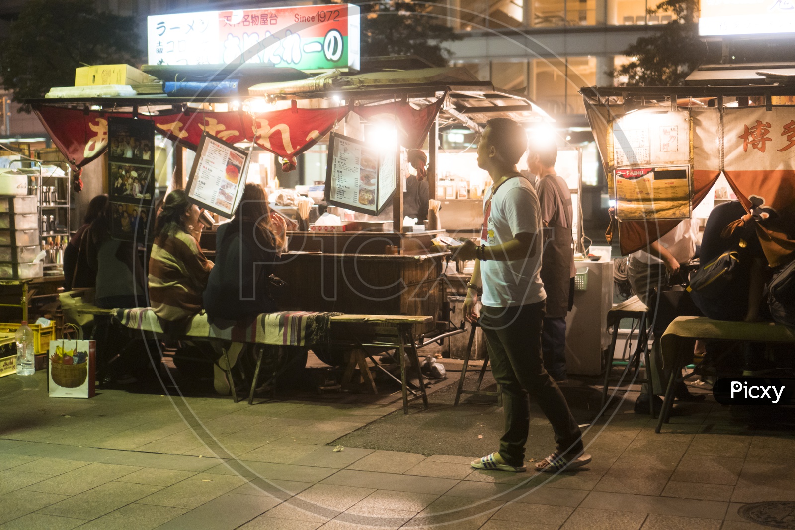 Japanes People in the streets eating at Yatai mobile food stall during night in Fukuoka, Kyushu, Japan