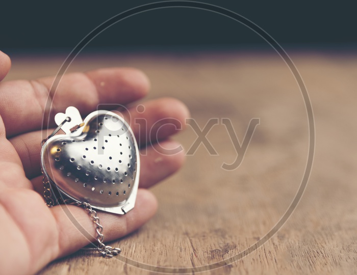 Heart shaped stainless steel locket with wooden background