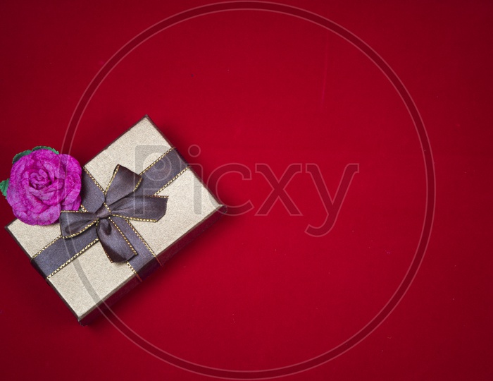 Gift box with a red rose on red background - abstract picture for Valentine day, vintage filter image