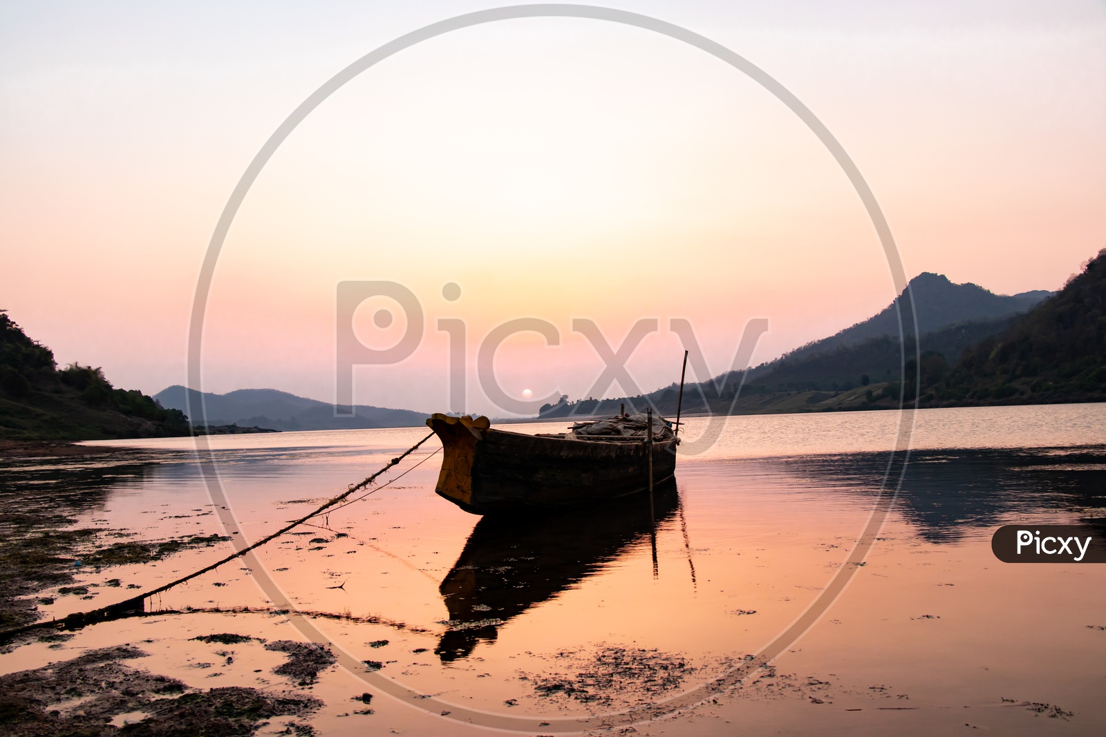 A Lone Fishing Boat In a River With Reflection at Sunset