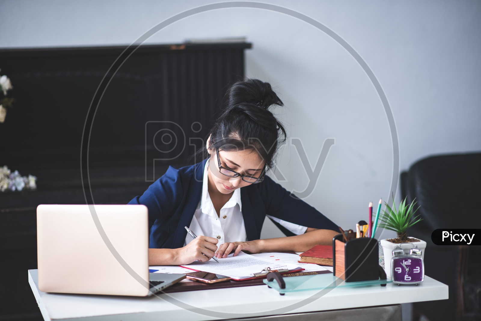 Young Asian Businesswoman filling Documents at workplace