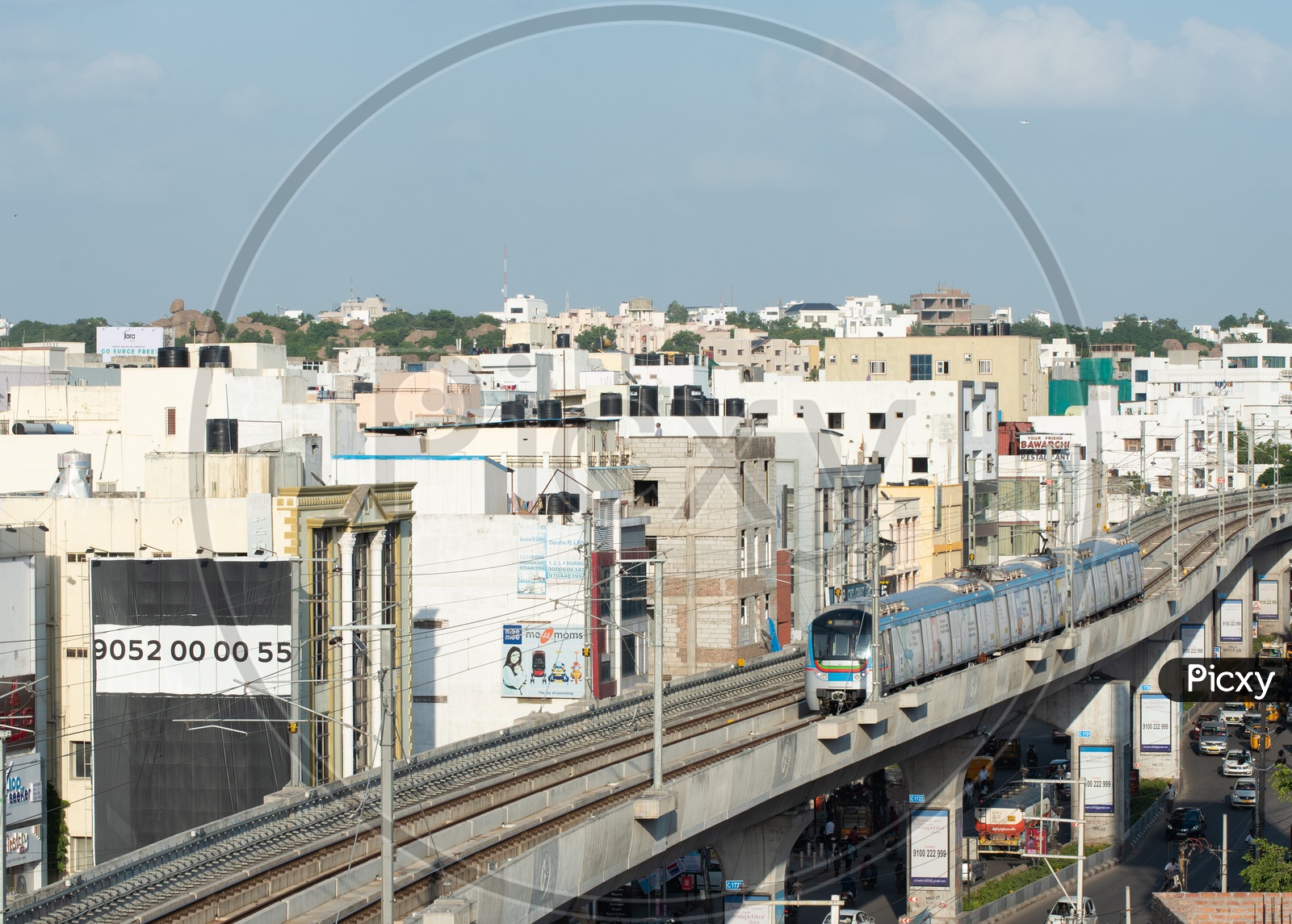 Hyderabad Metro Train running On Tracks  With High rise buildings in Background
