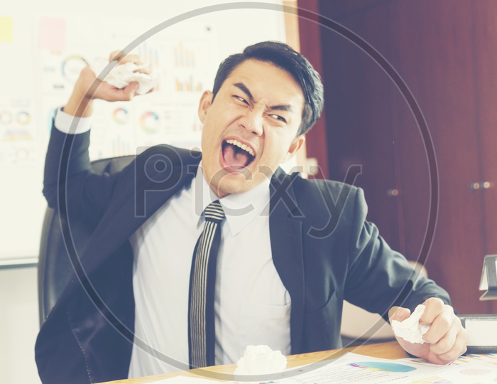 Concept of stress and frustration of a businessman with a crushed paper in hand