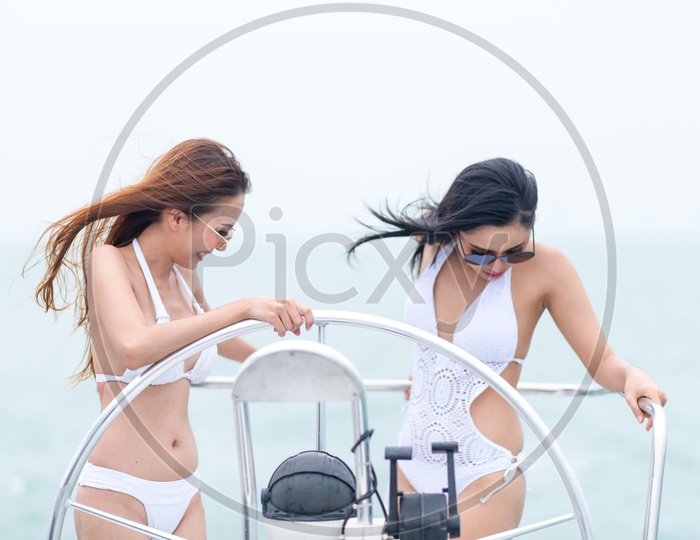 Sexy Beautiful girls in white bikini on a yacht in the sea