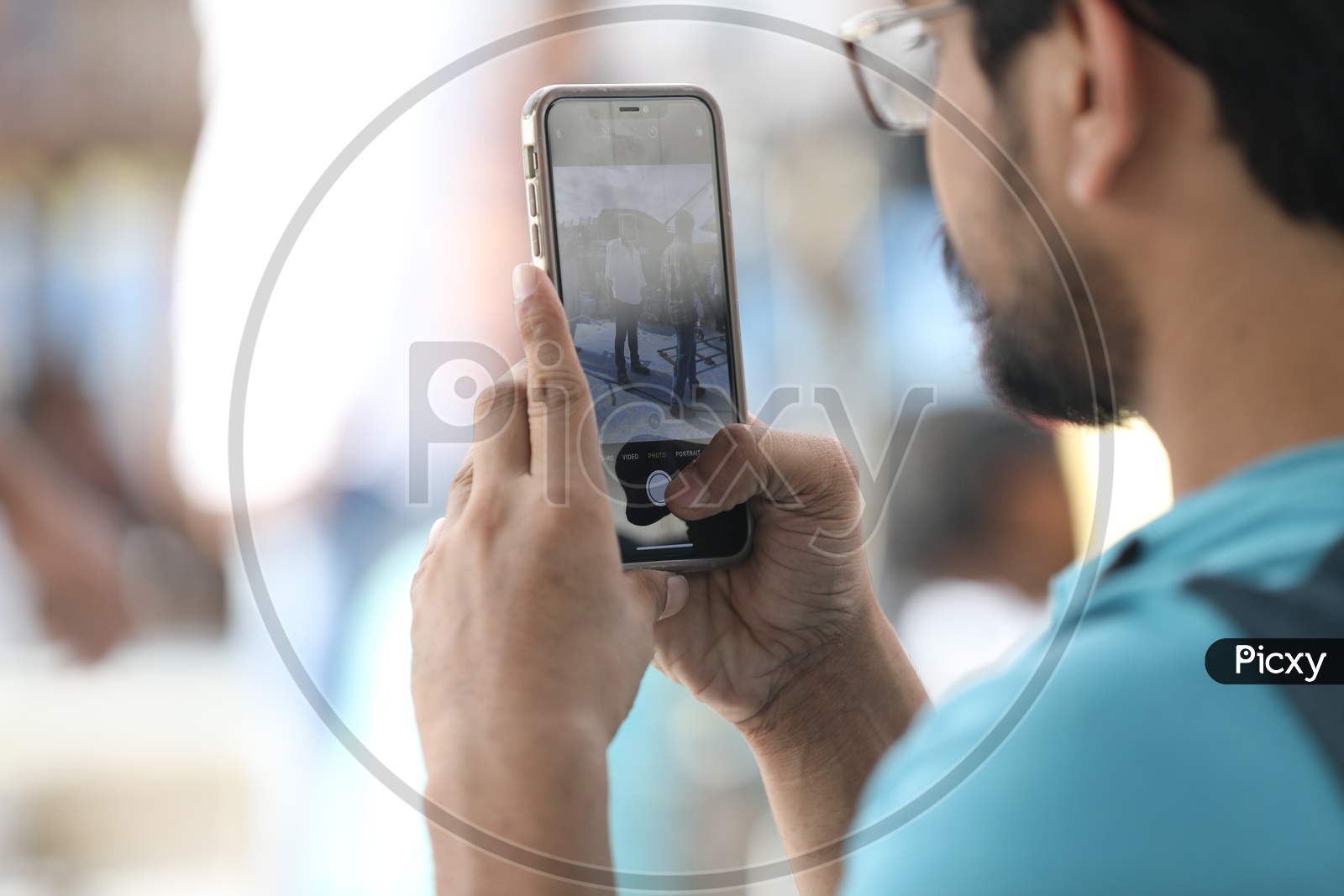 A Man taking a picture with an iPhone