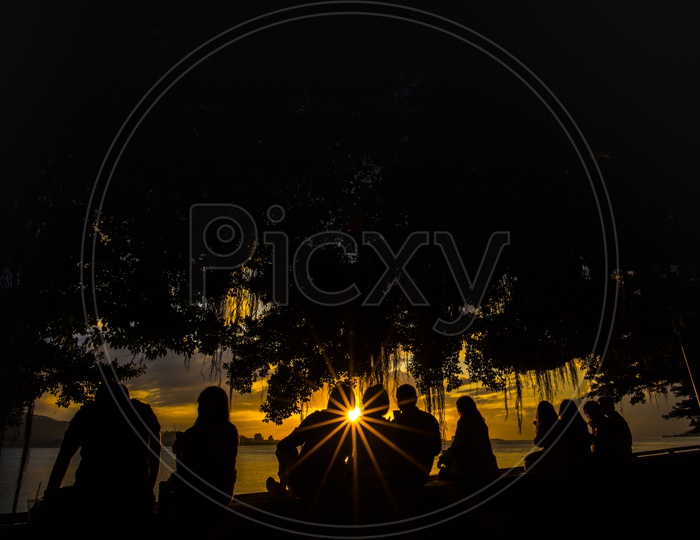 Silhouette of People with sunburst during a sunset in Thailand