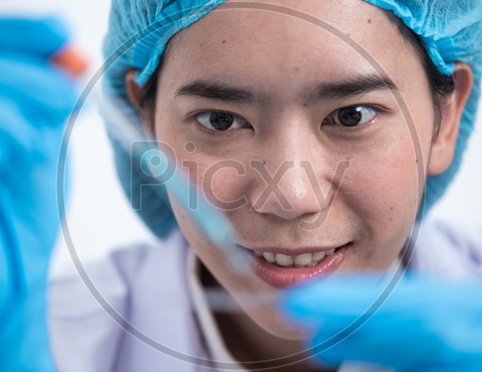 Young Asian Woman Medical Student or Scientist Analyzing a Sample
