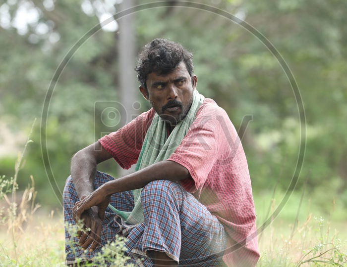 Indian Man sitting wearing a Lungi