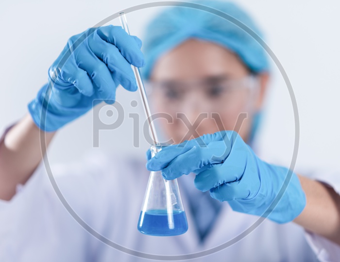 Young Asian Female Scientist Researching Chemical Solutions in Test Tube at Laboratory