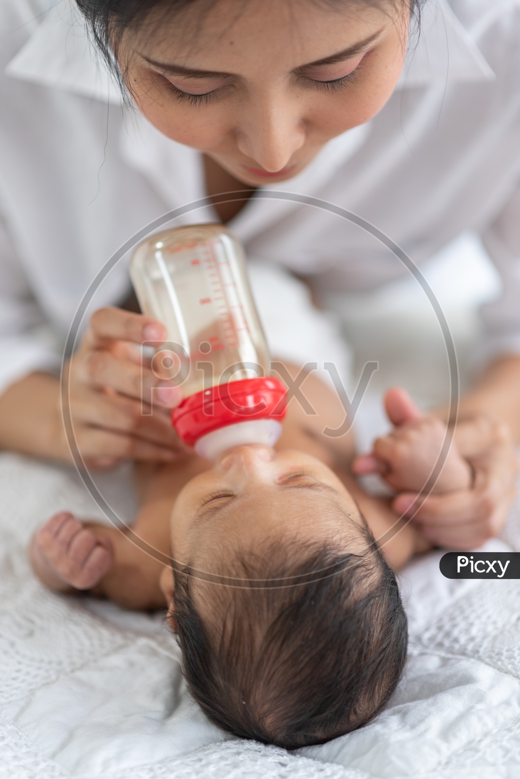 Asian Mother milk feeding using a baby bottle