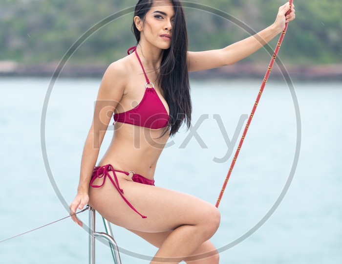 Asian Beautiful girl in Red Bikini on a yacht in Sea