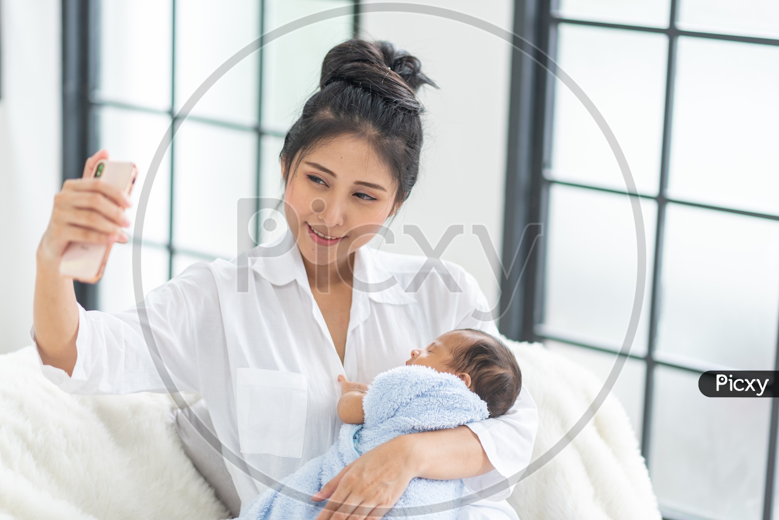 Asian Mother taking a selfie with her new born baby