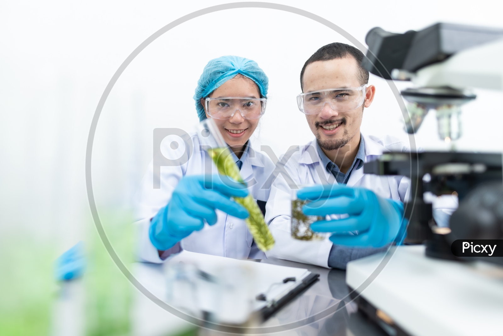 Asian Scientists Researching on Biofuel with Microscope in Foreground at Laboratory