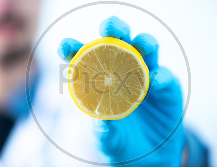 Asian Research Scientist Holding a Lemon in Hand at Laboratory