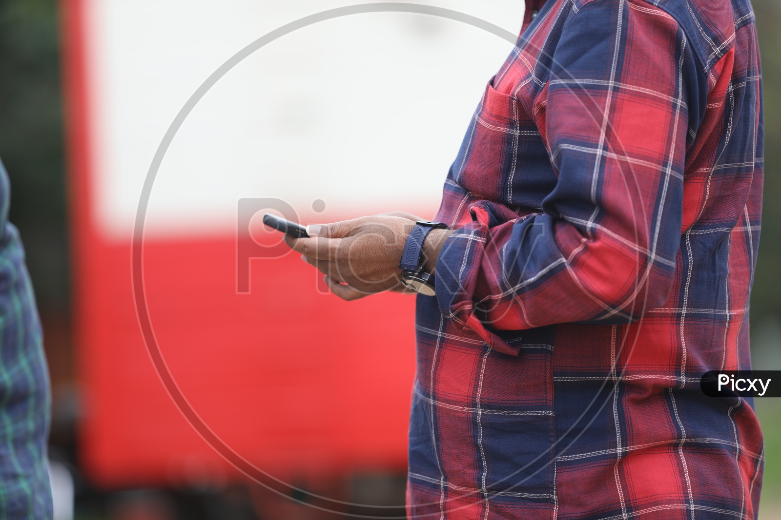 Indian Man wearing checkered shirt with mobile in hand