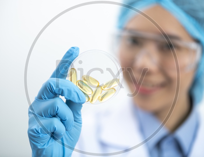 Young Asian Woman Holding Fish oil Pill or Capsule in Hand, Healthy Nutrition