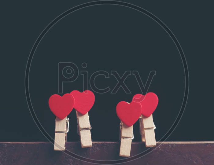 Love For Valentines Day With Red Hearts Couple Hung On an Isolated Black Background