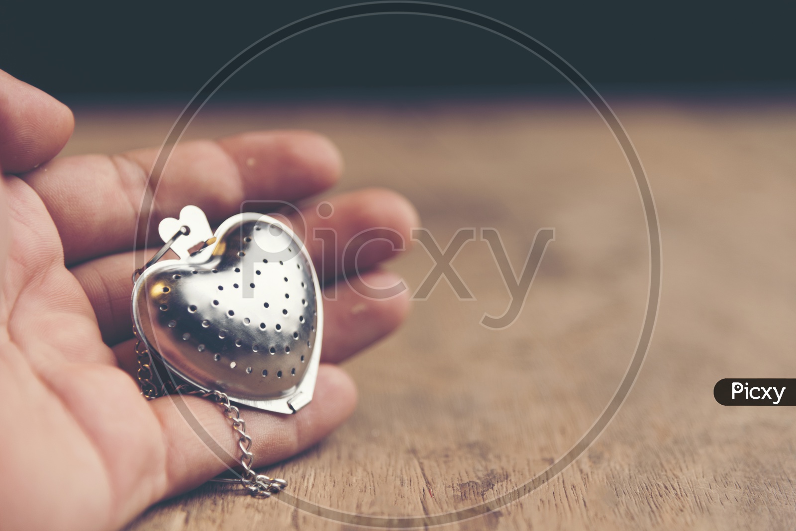 Heart shaped stainless steel locket with wooden background