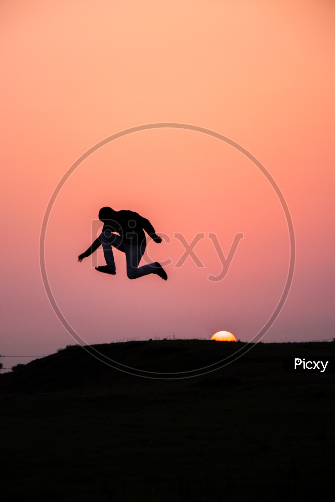 Silhouette Of Young Man Jumping In Joy