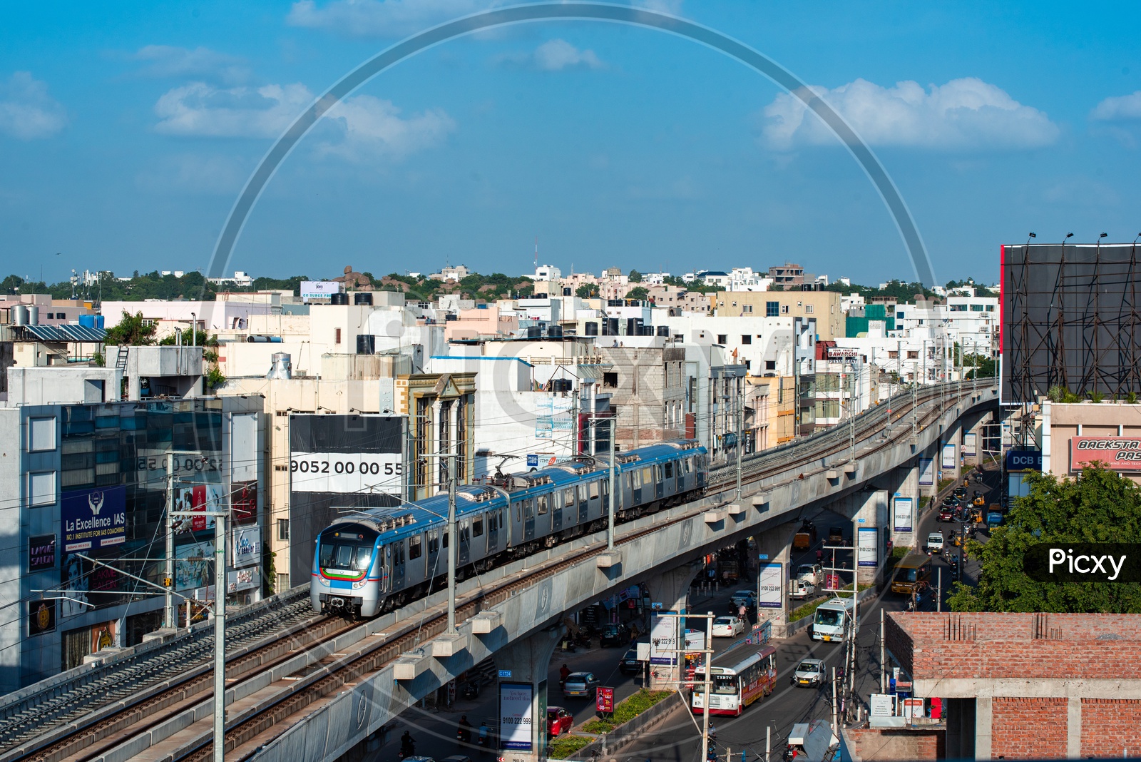 Hyderabad Metro Train running On Tracks  With High rise buildings in Background