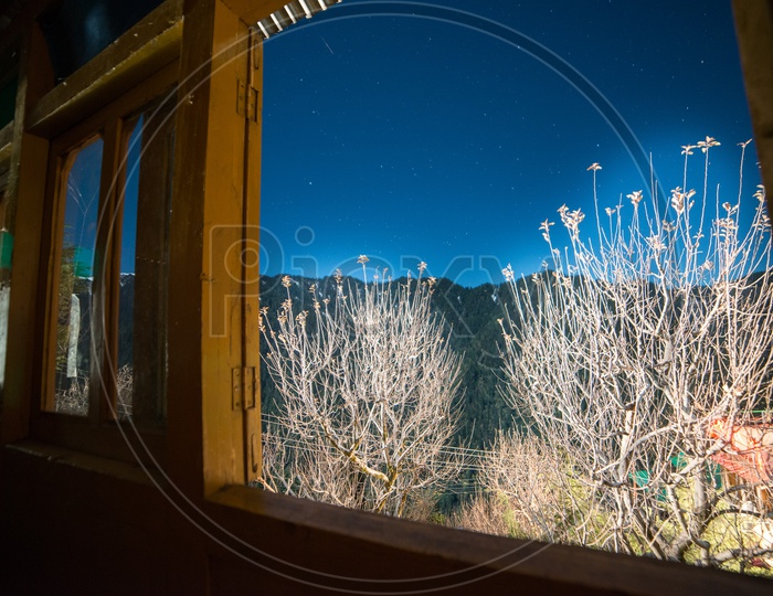 Starry Sky view form the window of wooden house in Manali