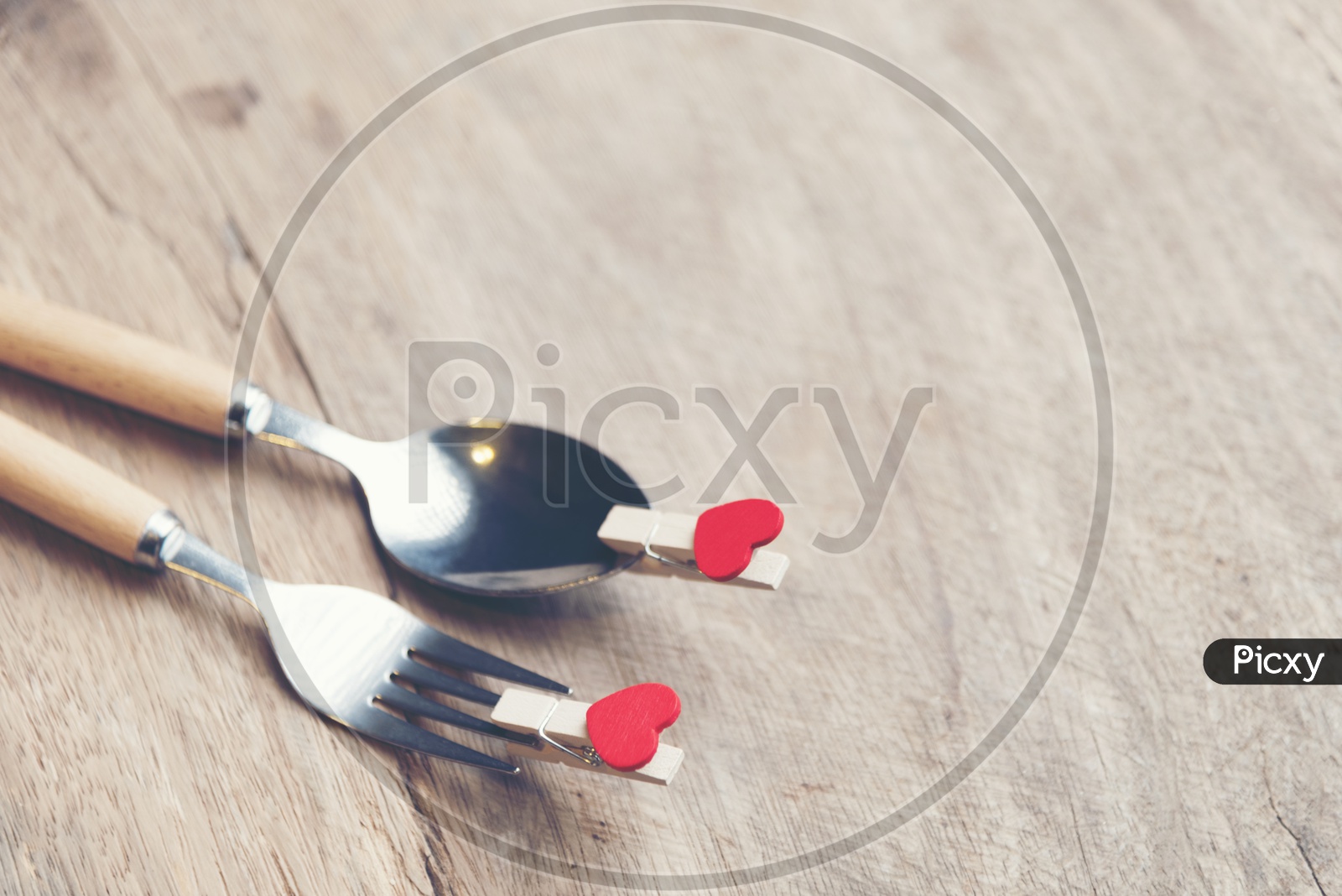 Love and  Valentines  Day Concept With Red Heart Shape Tagged To Spoon and Fork On an Wooden Table Background With Vintage Filter